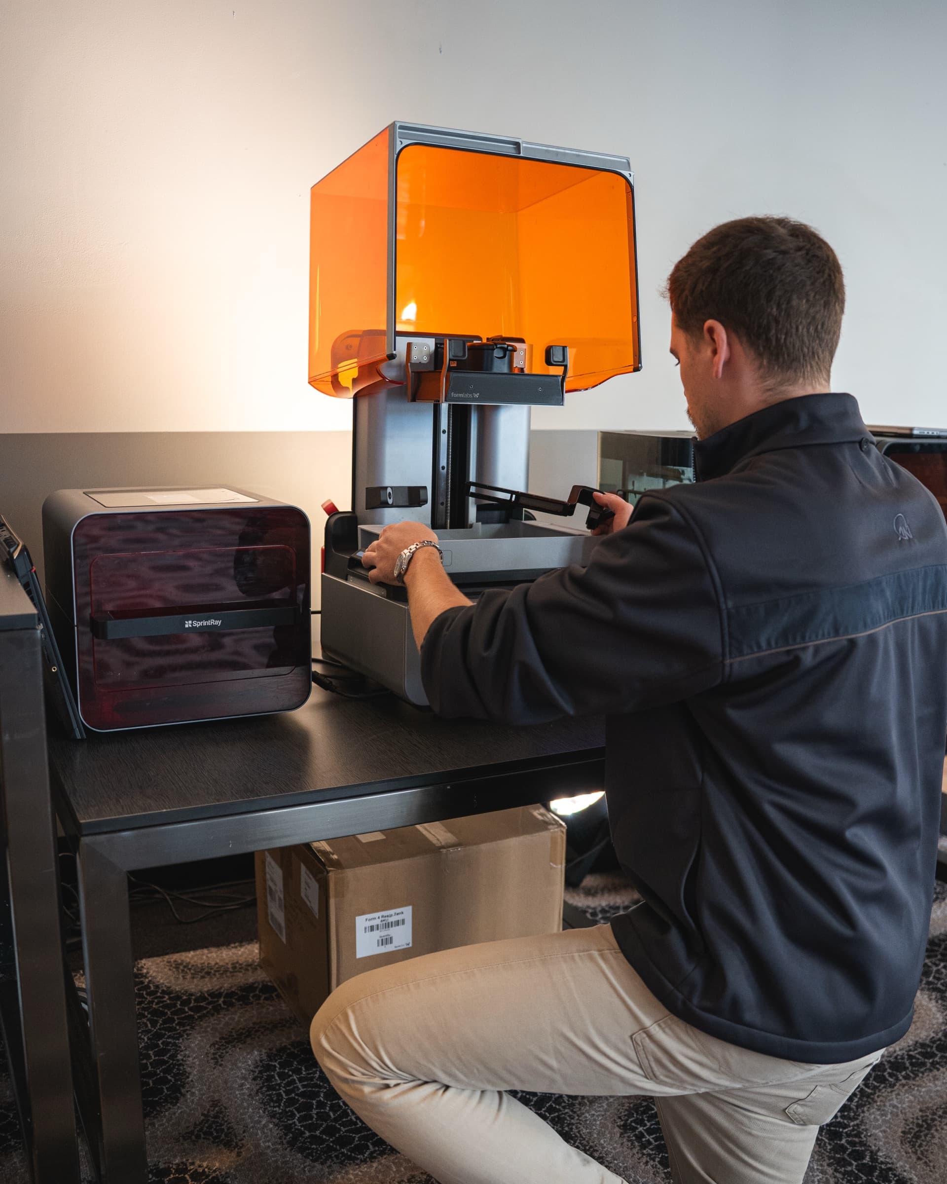 Hands-on training at a Formlabs Form 4, fitting the resin tank during an install